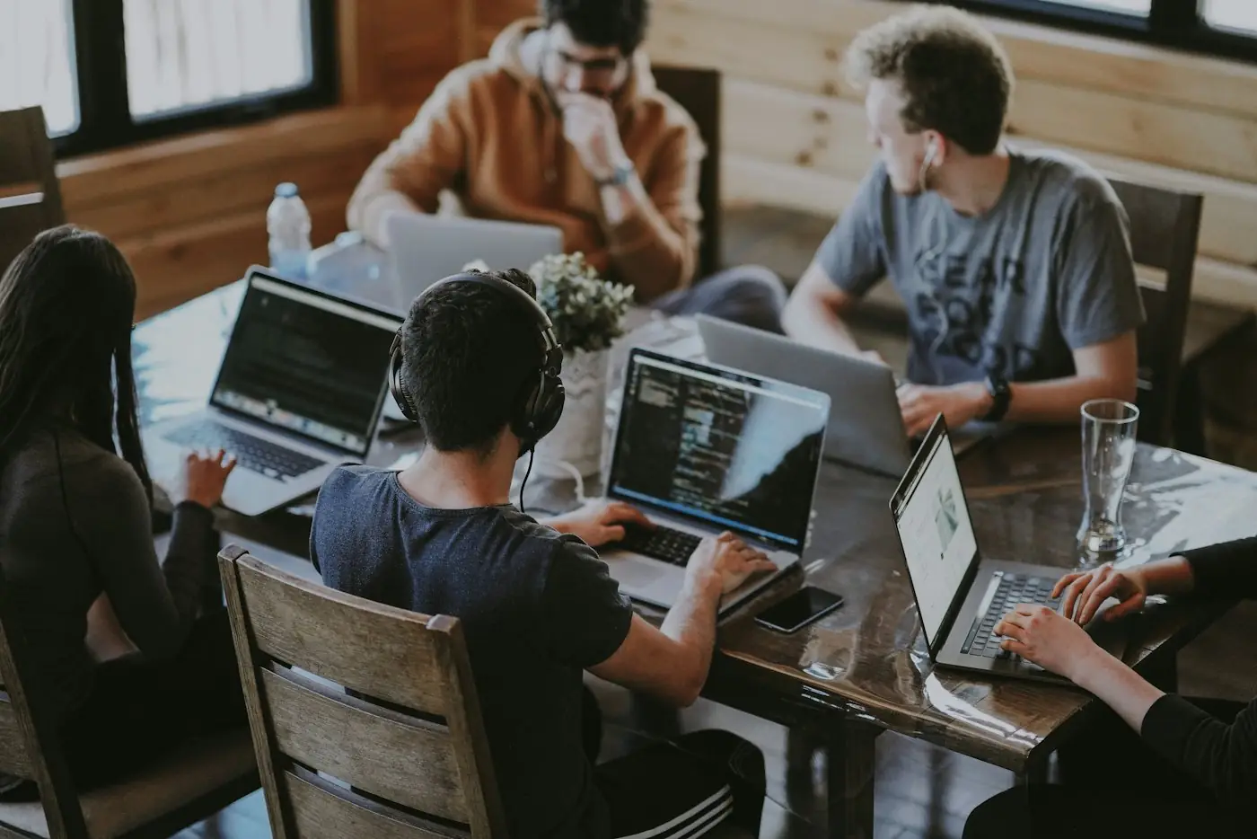 A team working alongside AI on laptops
